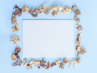 small sheet of paper on a blue table and dry flowers