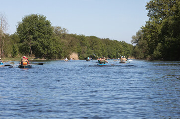 A large group of tourists kayaking on the Siverky Donets river. Big company in different canoes is travelling on sunny summer day. 