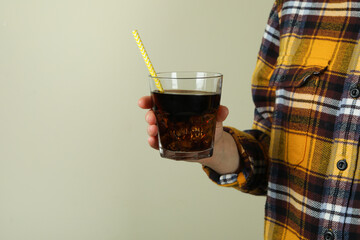 Woman hold glass of cola with ice, space for text