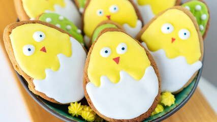 Cute chickens Easter background. Iced sugar cookies in bright frosting. Easter stilllife with funny butter biscuits. Ideas of cookies icing for family baking with children.