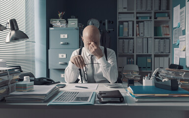 Tired stressed office worker rubbing his eyes