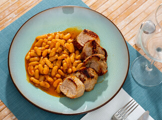 Delicious fried pork with beans in gravy on a plate