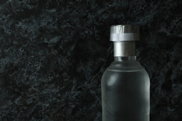 Blank bottle of vodka on black smokey background, space for text