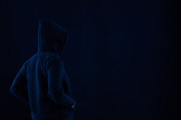 Faceless man wearing a dark black top for use with technology and cyber criminal concepts and ideas