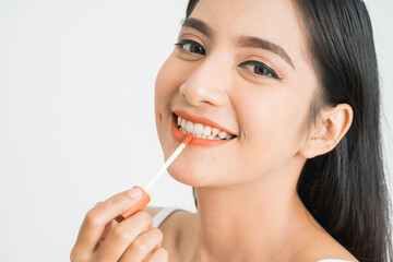 beauty face of asian woman. portrait of female applying lipstick on her face close up