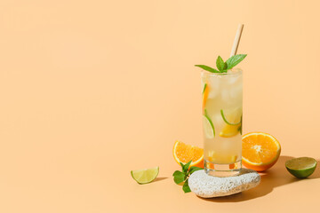 Cold summer lemonade or cocktail with orange and lime slice on color background. Refreshing drink.
