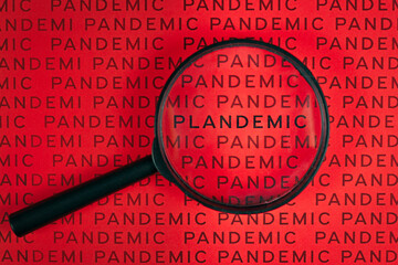 Magnifying glass over word 'Plandemic' between lines wird word 'Pandemic'. Concept for conspiracy...