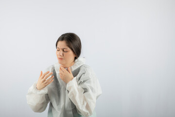 Portrait of young female doctor scientist in defensive lab coat coughing