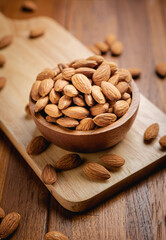 Almonds seed in the wooden bowl on the wooden table.