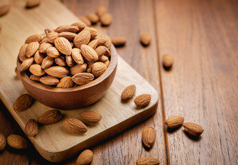 Almonds seed in the wooden bowl on the wooden table.