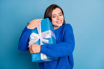 Photo of young happy positive good mood girl smiling embrace christmans present isolated on blue...