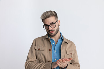 happy young man in denim shirt smiling and rubbing palms