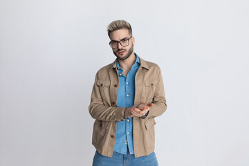 cool casual young man in denim shirt with glasses rubbing palms