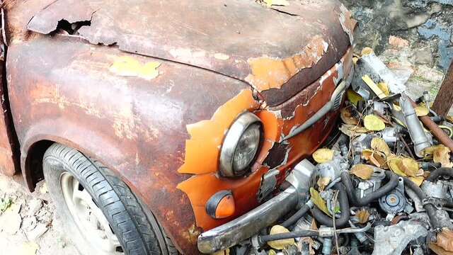 4K Old abandoned rusty white orange vintage car wreck in an old street