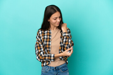 Young French woman isolated on blue background with pain in elbow