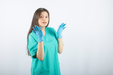 Female doctor in medical gloves showing hands on white background