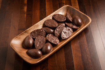 Mini halves of crunchy easter eggs on a wooden basket on a wooden table.