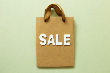 Shopping Bag and word 'sale' on green background. top view