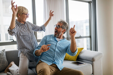 Happy senior couple in love hugging and bonding with true emotions at home