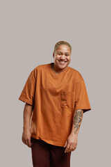 Vertical portrait of modern mixed race woman looking at camera and smiling while posing in studio...