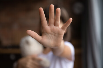 Crop close up of little girl child stretch hand show no gesture protest against domestic violence....
