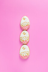 Beautiful Easter background or greeting card with colored pink gingerbread eggs on pink surface background. Happy Easter
