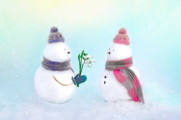 Snowmen in love wearing winter hats, scarves on a white background in pink and blue colors. Boy giving a rose flower to girl. Valentins day, love concept. 14th february.