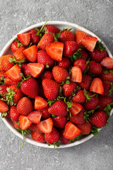 Ripe delicious strawberries on a white plate, top view