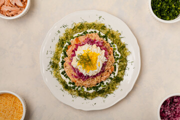 Traditional Russian Mimosa salad with salmon cheese and potatoes. Top view
