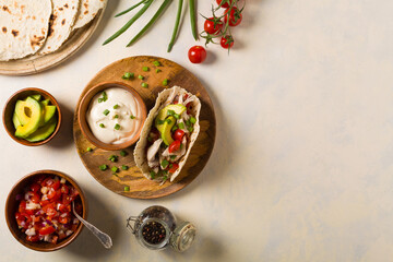 Obraz na płótnie Canvas Mini tortillas with tomato salsa, avocado and boiled chicken. Top view.
