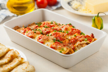 Baked pancakes with chicken in tomato sauce.