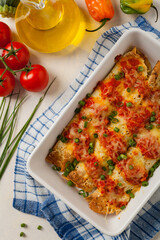 Baked pancakes with chicken in tomato sauce.