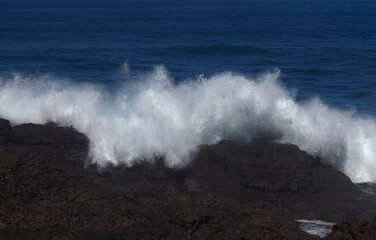 Gran Canaria, north coast, area around Punta Sardina cape, powerful foamy ocean waves breaking along the shore
