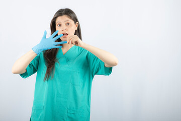 Female doctor in uniform taking off medical glove
