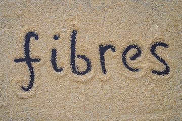 Quinoa on a black background and an inscription with a finger - fibers