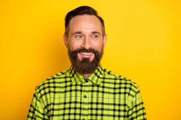 Photo of mature handsome man beard happy positive smile look empty space isolated over yellow color background