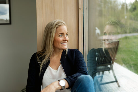 Blond woman looking through window