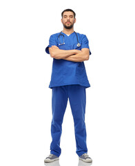 Fototapeta premium healthcare, profession and medicine concept - doctor or male nurse in blue uniform with stethoscope over white background