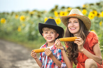 Beautiful mother and son eating corn outdoors
