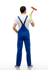profession, service and people - male worker or cleaner in overal and gloves with window cleaning...