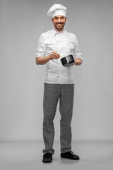 cooking, culinary and people concept - happy smiling male chef in toque with pot or saucepan over grey background
