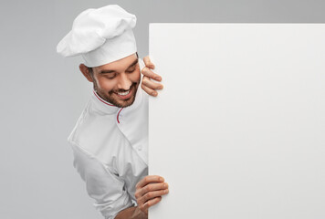 cooking, culinary and people concept - happy smiling male chef in toque with big white board over grey background