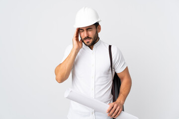 Young architect man with helmet and holding blueprints isolated on white background with headache