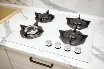 Modern gas stove on counter top white closeup. Hob gas stove using natural gas or propane for...