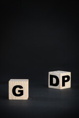 GDP gross domestic product concept and economic recovery idea. GDP written on wooden cube on black background