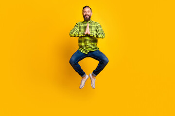Fototapeta na wymiar Full size photo of handsome man happy positive smile jump up meditate yoga zen isolated over yellow color background