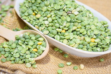 Dry green peas in a bowl. Peas as a natural product and healthy food. Peas, spoon, burlap, saucer.