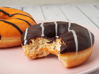 Delicious glazed donuts on white wooden table. Space for text