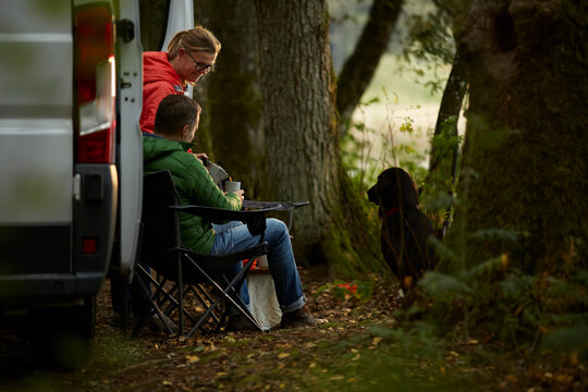 Couple Enjoying Coffee Break Near Car