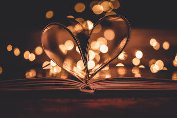 Heart created with the pages of a book on a light bokeh background